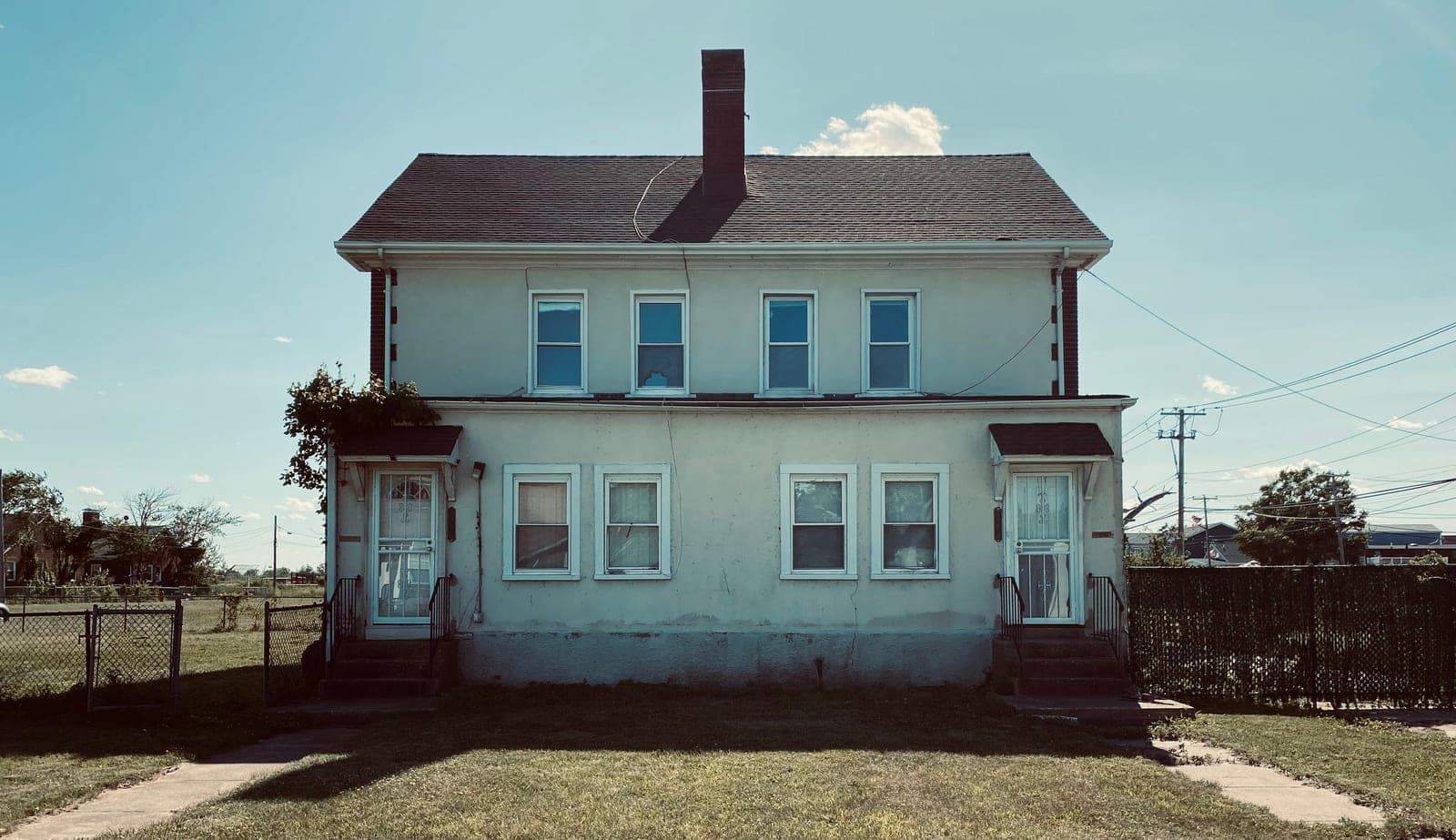Two-family house with twin front doors and a lawn, the kind of home movers in Pawtucket, RI handle every week
